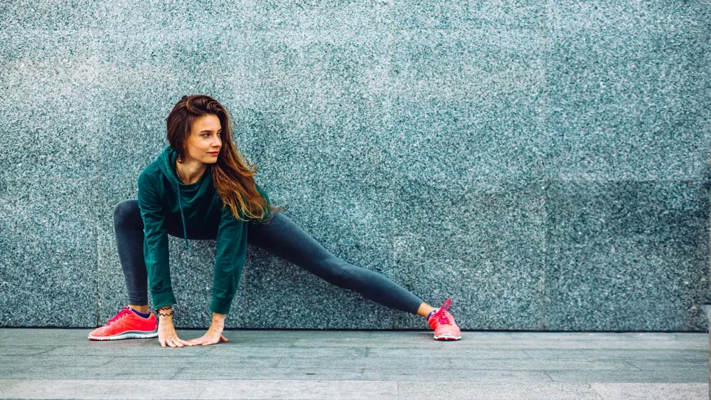 Fitness sport girl in fashion sportswear doing yoga fitness exercise in the street, outdoor sports, urban style